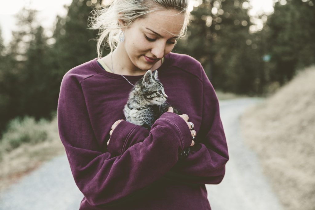 Woman with a soft smile, holding a kitten. Healing my self-image. Rediscovering yourself after trauma.